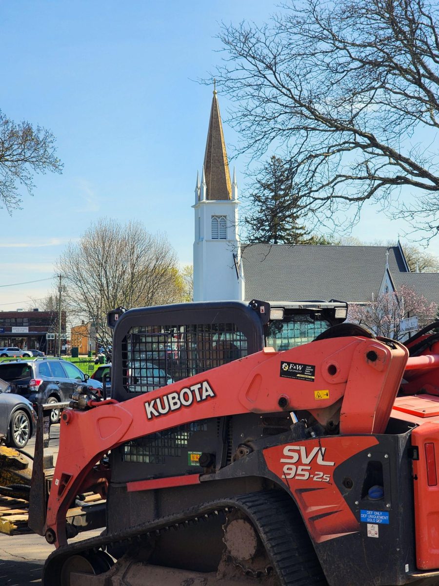 A piece of machinery sits ready to work on the Green, with Trinity Episcopal Church in the background.