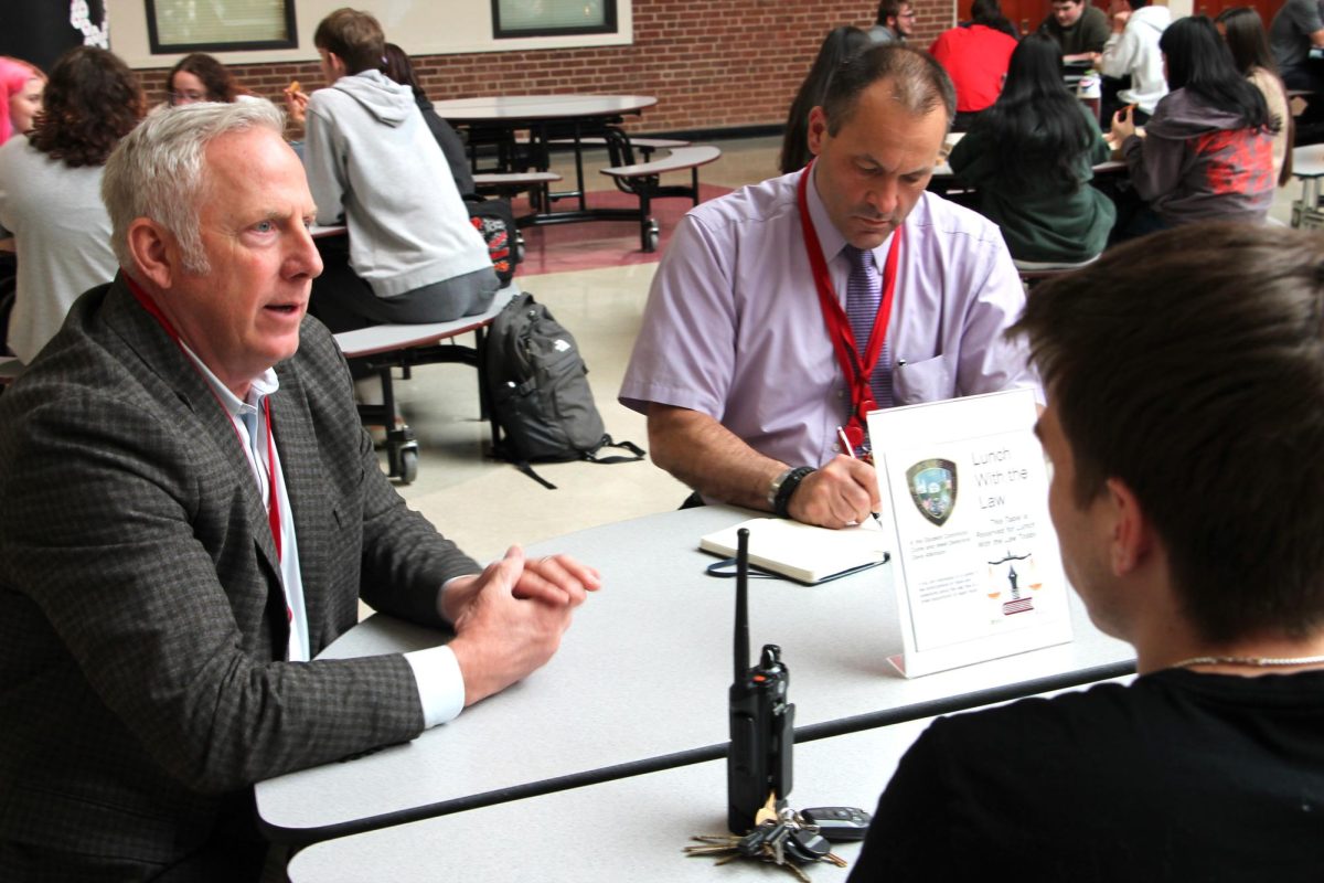 Branford Police Detective Dave Atkinson, left, who is assigned to the high school, meets with students regularly as part of the Lunch with the Law program with teacher John Alibinger, right.