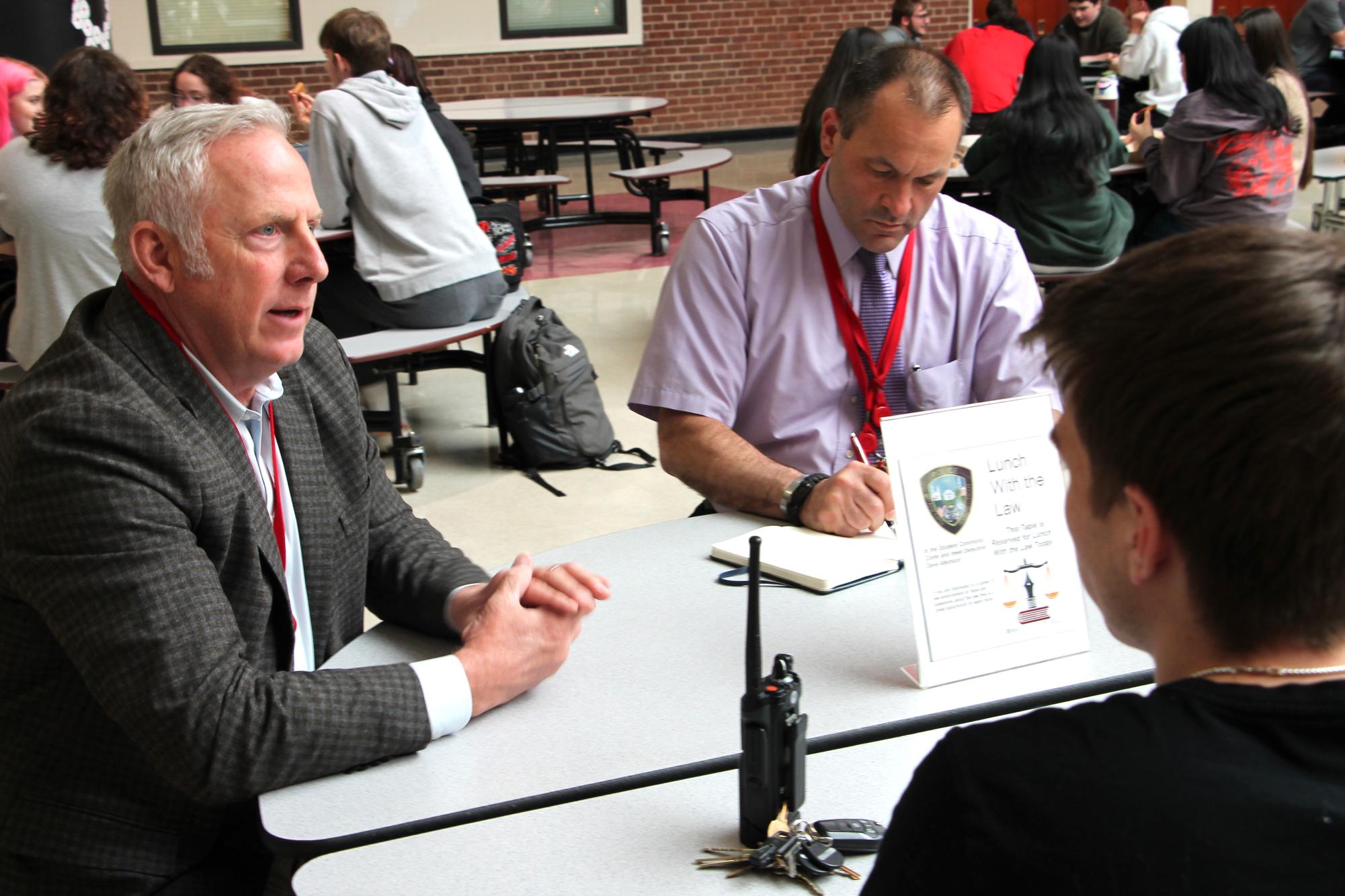 Branford Police Detective Dave Atkinson, left, who is assigned to the high school, meets with students regularly as part of the Lunch with the Law program with teacher John Alibinger, right.