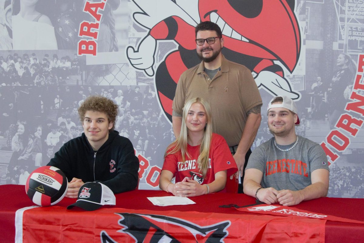 Stella Andresen, center, plans to continue playing volleyball next year at Keene State College. Here she poses with her brothers and coach, Michael Martone.