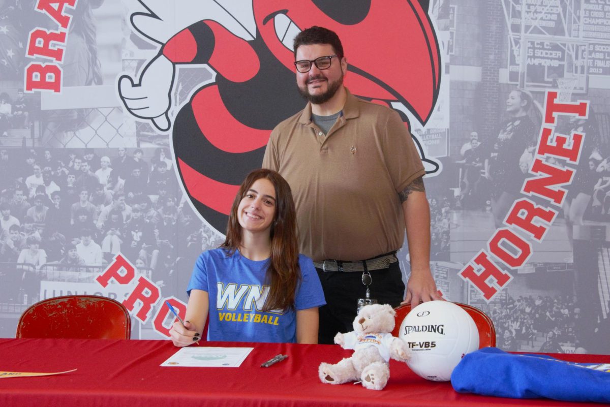 Julianne Henkel and volleyball coach Michael Martone pose during this week's signing ceremony.