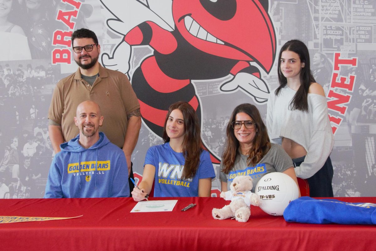Volleyball player Julianne Henkel, center, poses with her coach Michael Martone and family members while signing to play next year at Western New England College.