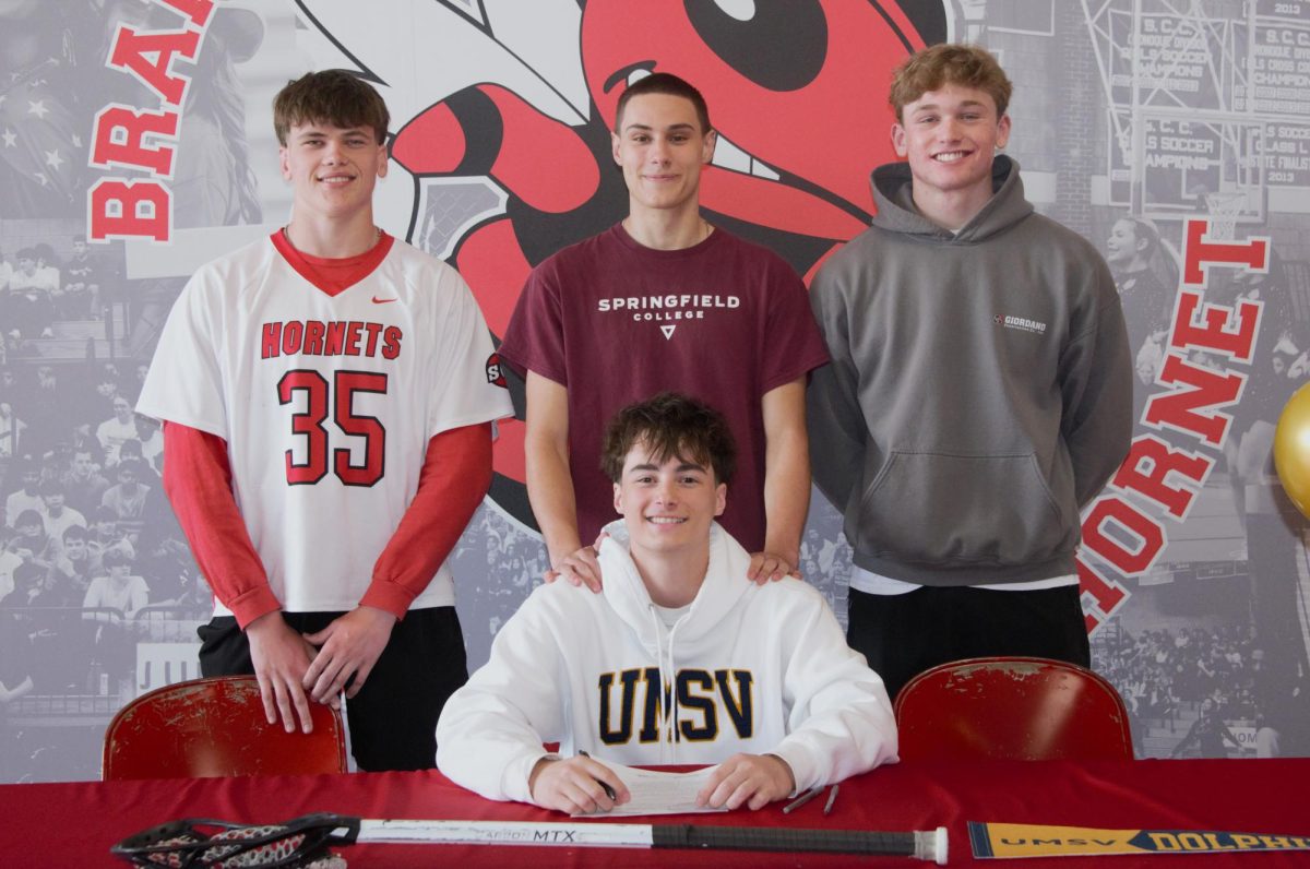 Lacrosse player Keegan Walsh, center, poses with his teammates and friends while taking part in the recent BHS signing day.