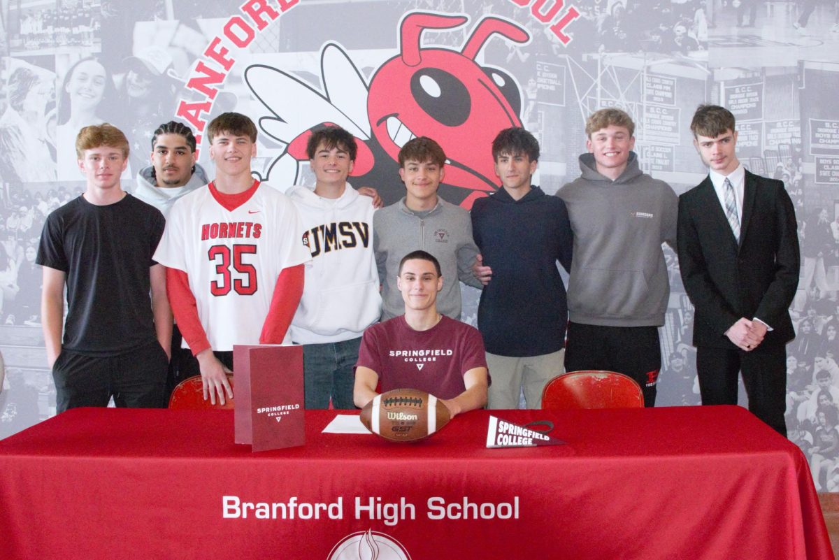 Football player Alex Leblanc, center, poses with friends and teammates after signing to play at Springfield College next year.