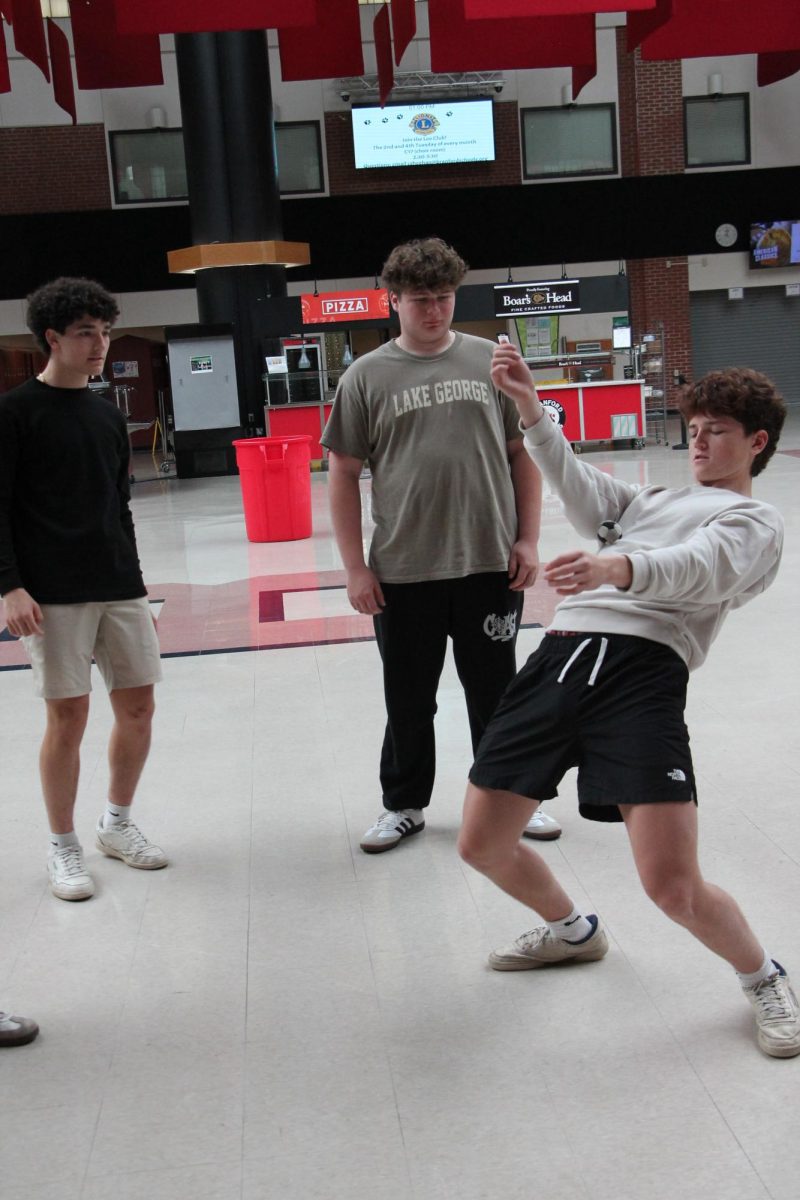 Liam Watson '26 catches the sack on his stomach while his fellow footbaggers watch in amazement.
